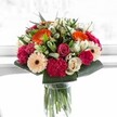 This bouquet seems suspended in a moment of pure joy-vivid, welcoming, and alive with the best of Mitcham's friendly atmosphere. Brilliant orange gerberas radiate warmth at the heart of the design, flanked by blushing pink roses and sumptuous magenta carnations that bring both depth and luxurious texture. Creamy ivory roses and soft peach gerberas offer a gentle counterpoint, lending an air of soft harmony and affection. Crisp, glossy greenery weaves below and around, cradling the blooms and giving the arrangement structure reminiscent of the leafy lanes of Mitcham. The lighting is bright and natural, highlighting the intricate veins and petal contours, making the colours dance with life. Perfect for birthdays, anniversaries, or simply sending cheer to a loved one in the Mitcham community, this bouquet is carefully crafted with thoughtful artistry and a passion for seasonal beauty, reflecting both the vibrancy and warmth that define local floristry in this beloved neighbourhood.
